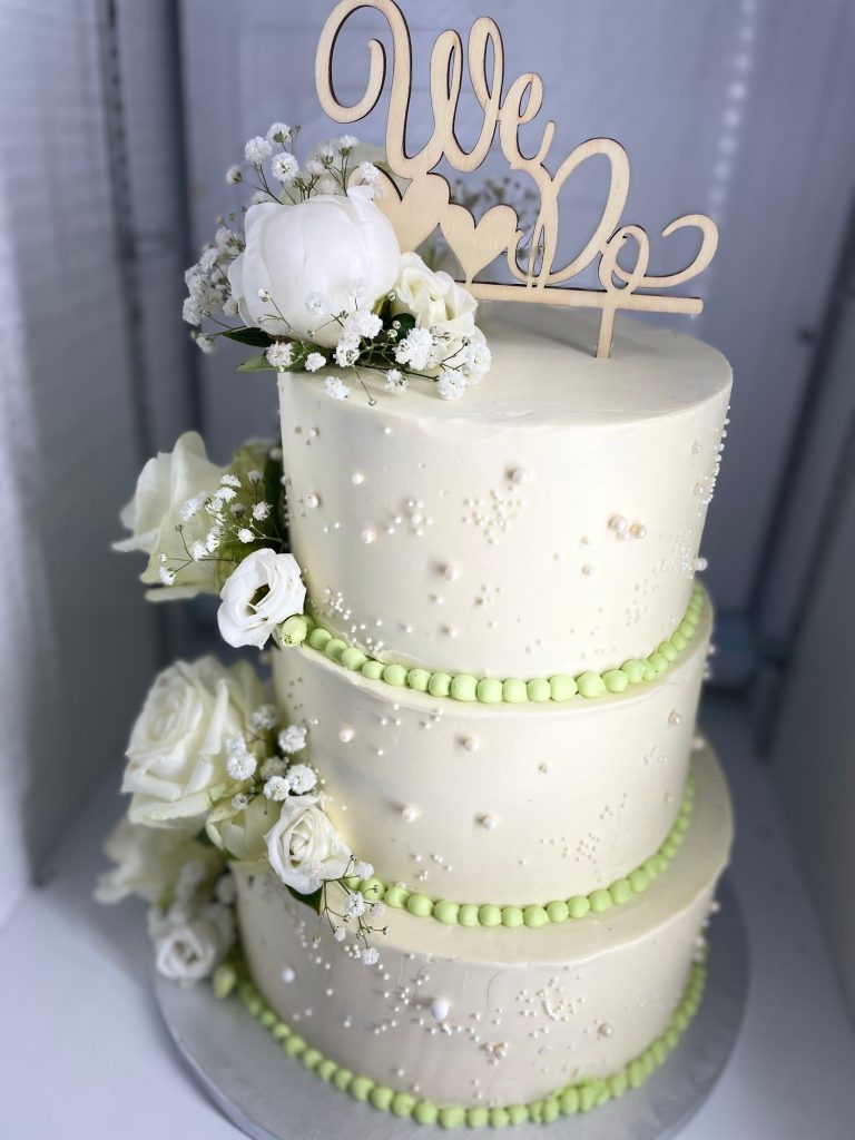 Dreistöckige Hochzeitstorte in Elfenbein mit weißen Blumen, Perlen und We-Do-Topper